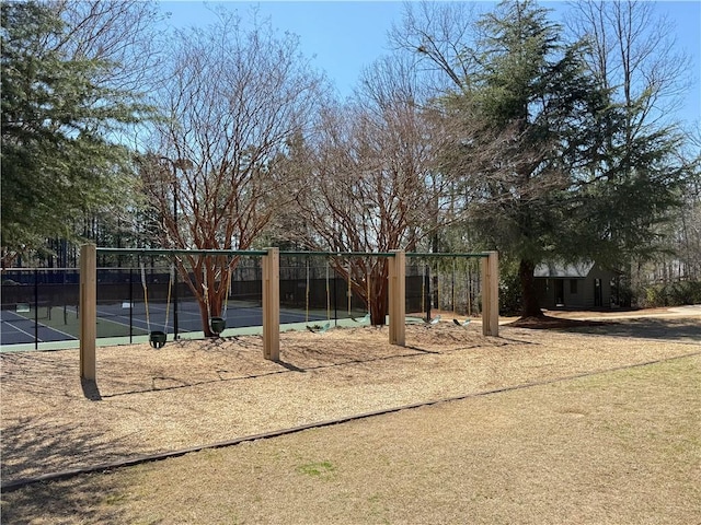 view of play area with a tennis court and fence