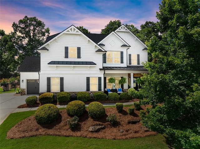 2213 Independence Ln, Buford, GA 30519 - modern farmhouse style home featuring a standing seam roof, concrete driveway, a garage, a porch, and a metal roof