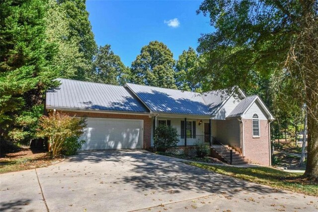 ranch-style home with a garage and covered porch