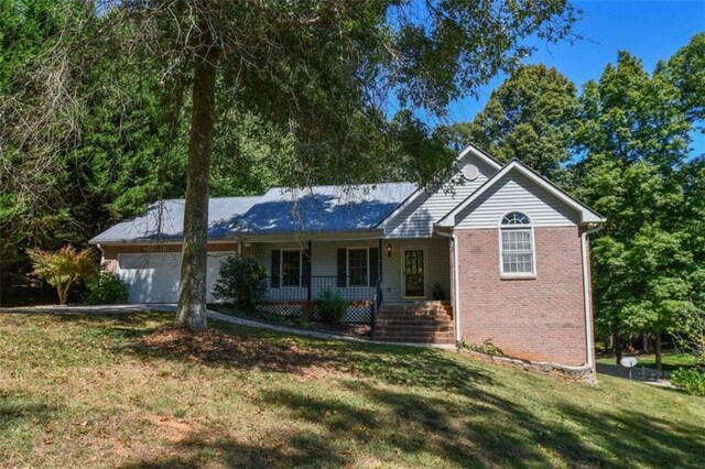 ranch-style home featuring a porch, a garage, and a front yard