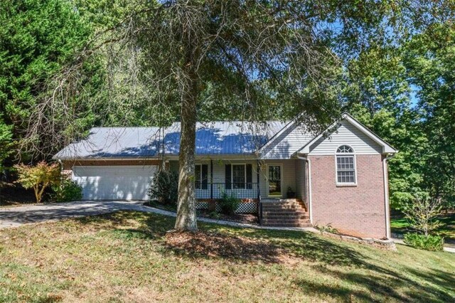 single story home featuring a front yard, a garage, and a porch