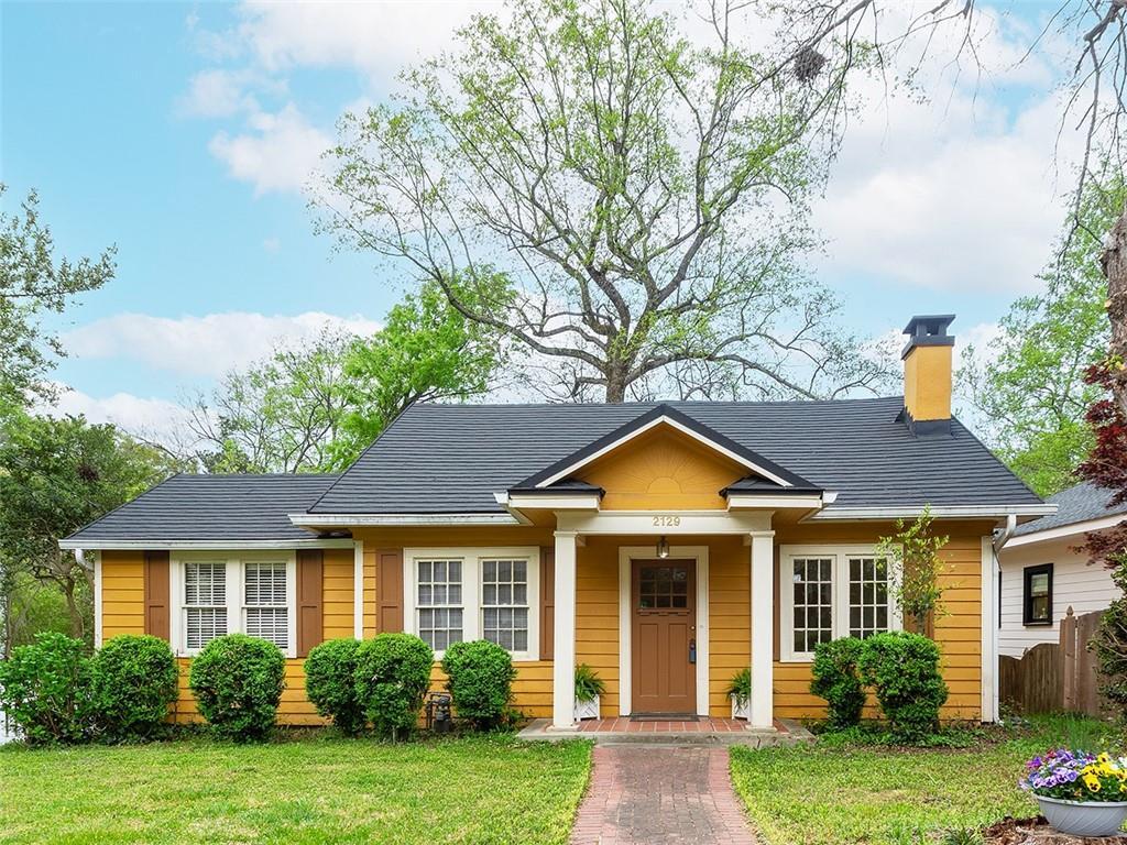 view of front of home featuring a front lawn, fence, and a chimney