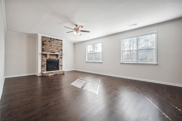 unfurnished living room with a stone fireplace, ceiling fan, dark hardwood / wood-style flooring, and ornamental molding