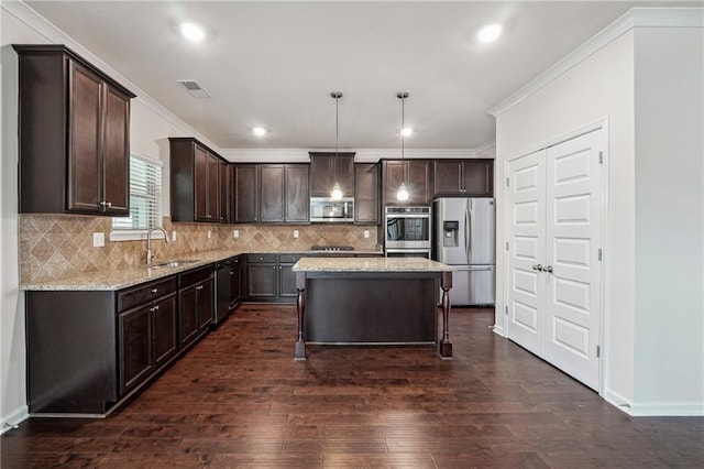 kitchen with light stone countertops, a center island, dark hardwood / wood-style flooring, pendant lighting, and appliances with stainless steel finishes