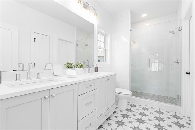 full bathroom with a sink, toilet, double vanity, and a stall shower
