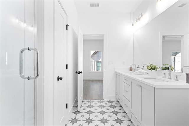 bathroom with tile patterned floors, a sink, visible vents, and a wealth of natural light