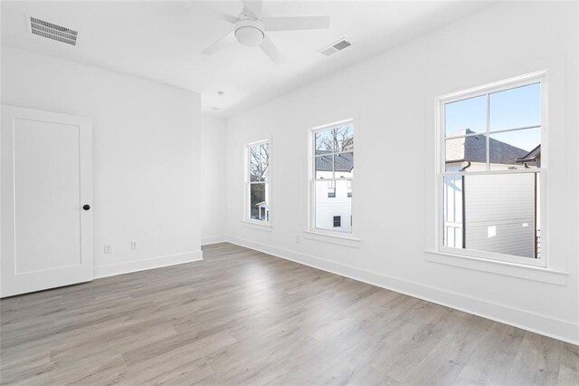 empty room featuring visible vents, baseboards, ceiling fan, and wood finished floors