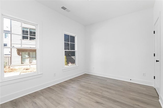 empty room with visible vents, baseboards, and wood finished floors