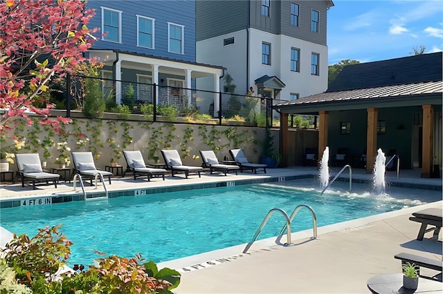 pool with a patio area and fence