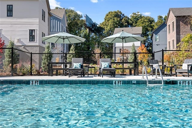 community pool with a patio and fence