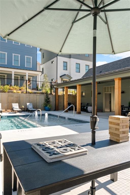 community pool with fence and a patio