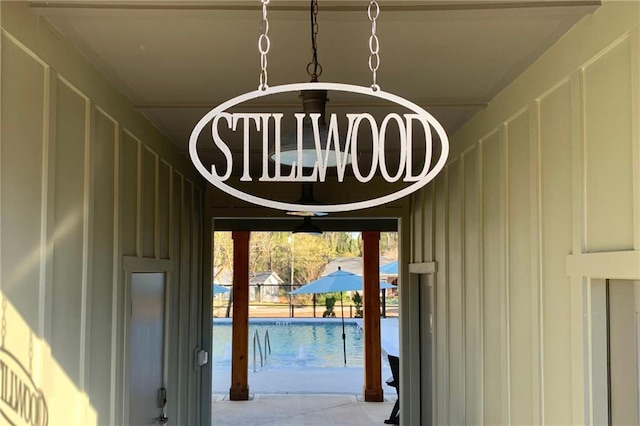 details featuring a chandelier, a swimming pool, and board and batten siding