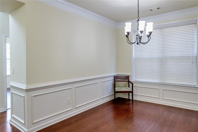 unfurnished dining area featuring ornamental molding, dark wood-type flooring, and a notable chandelier