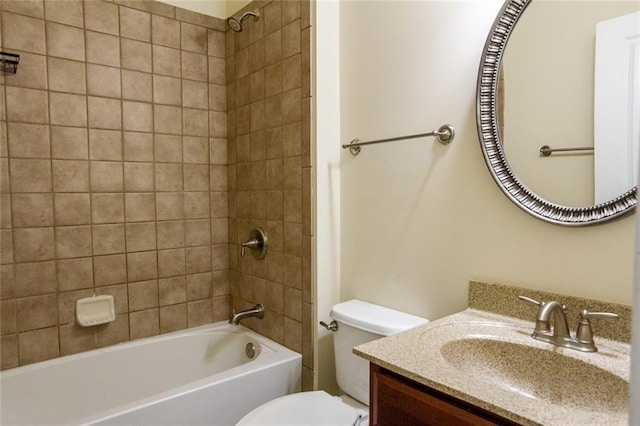 full bathroom featuring tiled shower / bath, vanity, and toilet