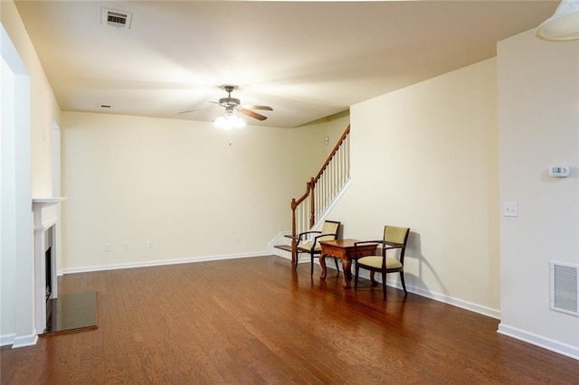 sitting room featuring dark wood-type flooring and ceiling fan