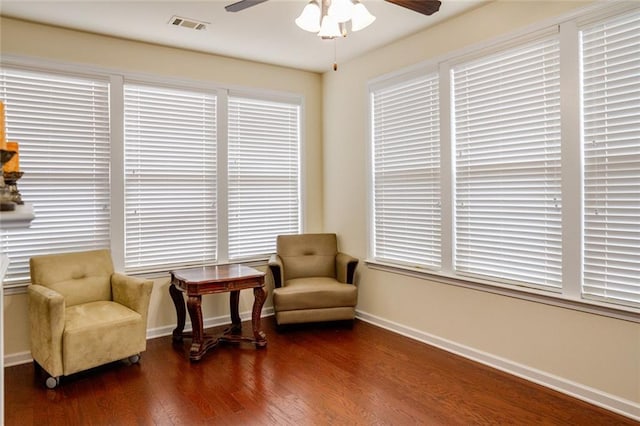 living area with dark wood-type flooring and ceiling fan