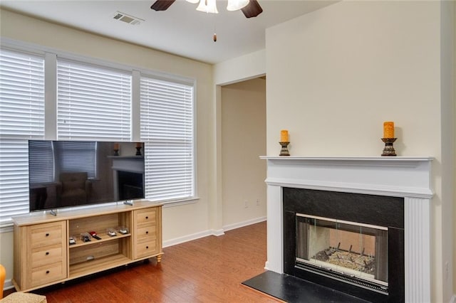 living room with ceiling fan and dark hardwood / wood-style floors