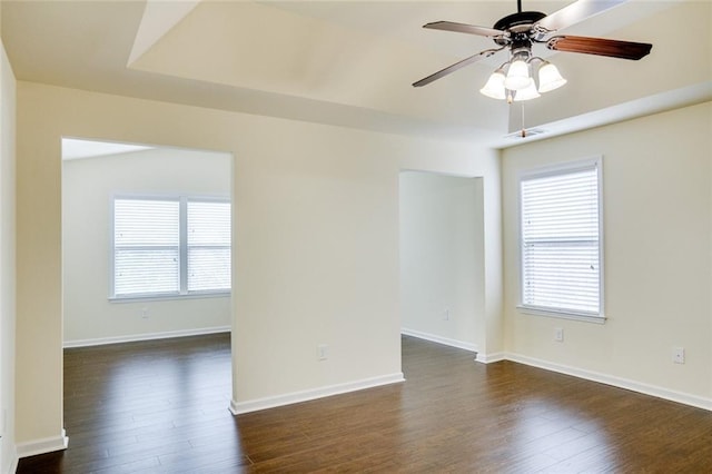 unfurnished room featuring ceiling fan, dark hardwood / wood-style flooring, and a wealth of natural light