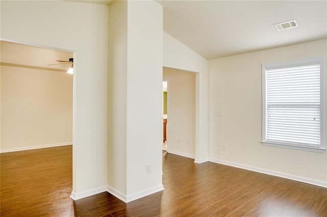 empty room with lofted ceiling, dark wood-type flooring, and ceiling fan