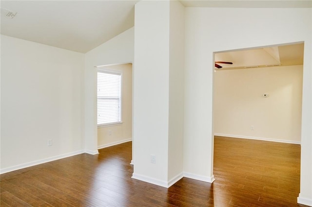 empty room with ceiling fan, dark hardwood / wood-style flooring, and vaulted ceiling