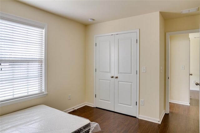 bedroom featuring dark hardwood / wood-style floors and a closet