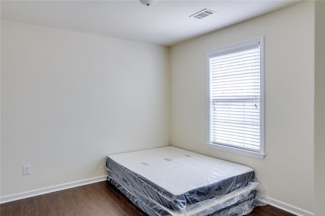 bedroom with dark wood-type flooring