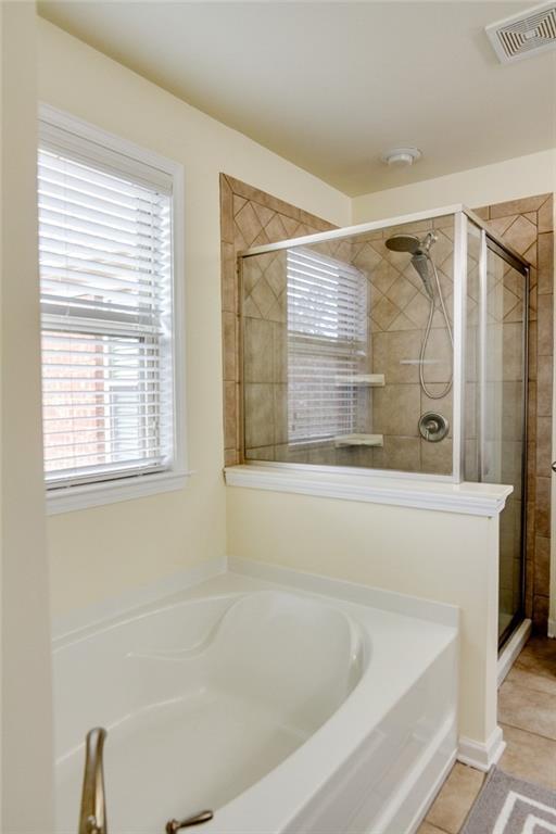 bathroom with tile patterned floors and shower with separate bathtub