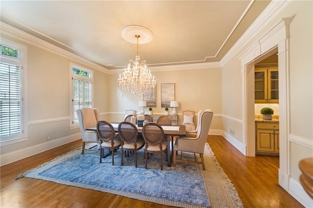 dining room featuring a notable chandelier, crown molding, hardwood / wood-style flooring, and plenty of natural light