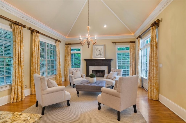 living room with a notable chandelier, crown molding, lofted ceiling, and light hardwood / wood-style floors