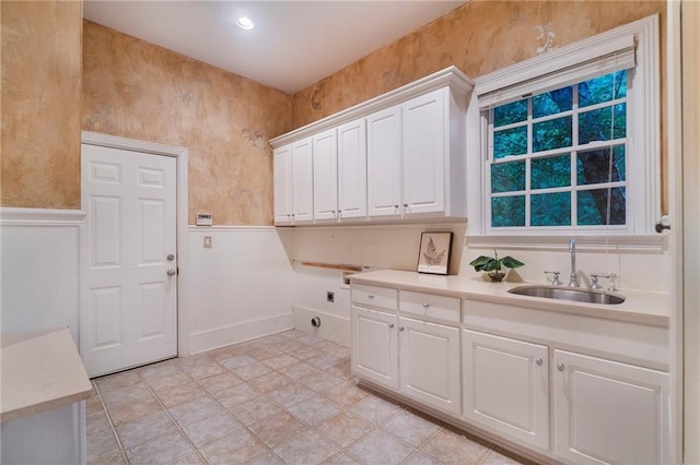 laundry room with cabinets, electric dryer hookup, sink, and light tile floors