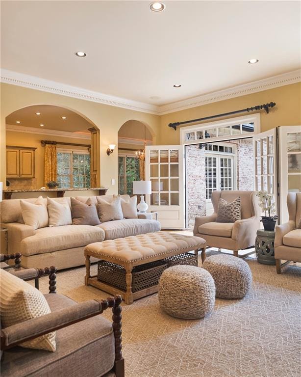 carpeted living room with ornamental molding and a notable chandelier