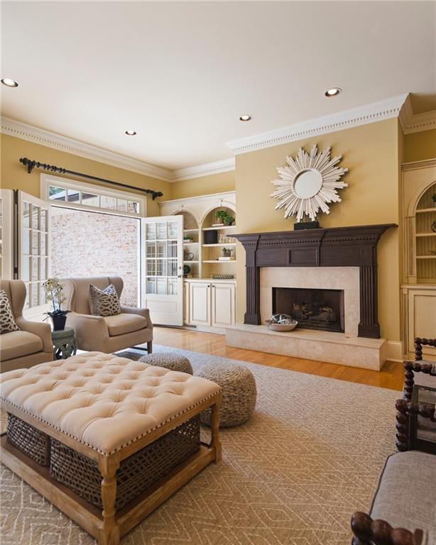 living room featuring hardwood / wood-style flooring, ornamental molding, a premium fireplace, and plenty of natural light