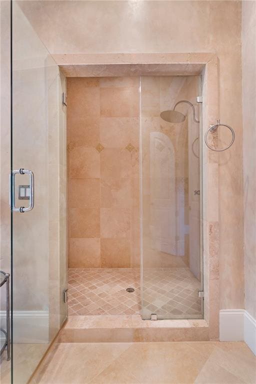 bathroom featuring tile floors and a shower with door