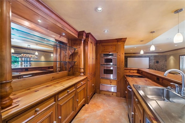 kitchen with wooden counters, hanging light fixtures, appliances with stainless steel finishes, and sink