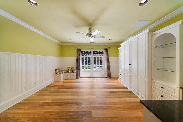 unfurnished room with crown molding, french doors, ceiling fan, and light wood-type flooring