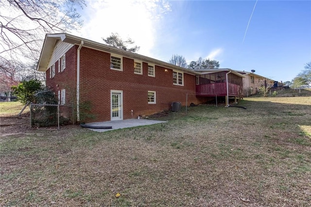 rear view of house featuring brick siding, a patio, central air condition unit, a lawn, and fence