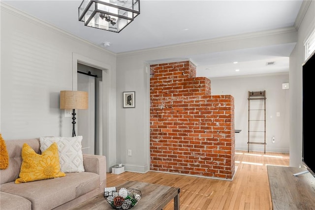 living room featuring light hardwood / wood-style floors, a barn door, and ornamental molding