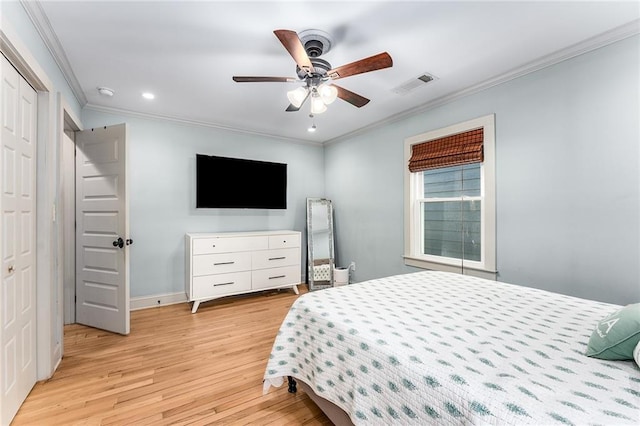 bedroom featuring a closet, light hardwood / wood-style floors, ceiling fan, and ornamental molding