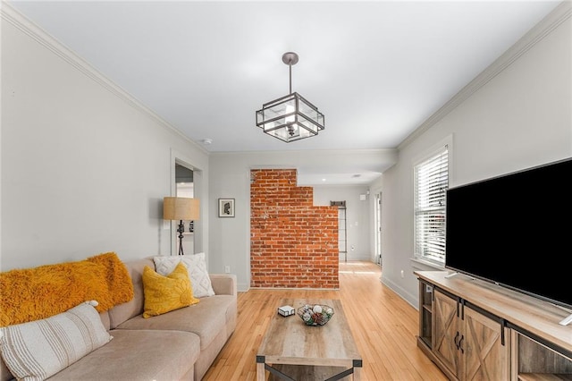 living room featuring light hardwood / wood-style flooring, a chandelier, and ornamental molding