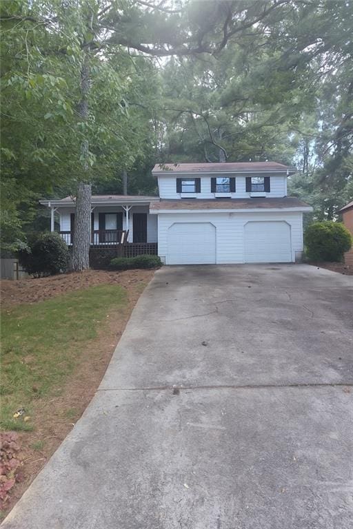 2857 Mountbery Dr, Snellville, GA 30039 - view of front facade featuring concrete driveway, a garage, and covered porch