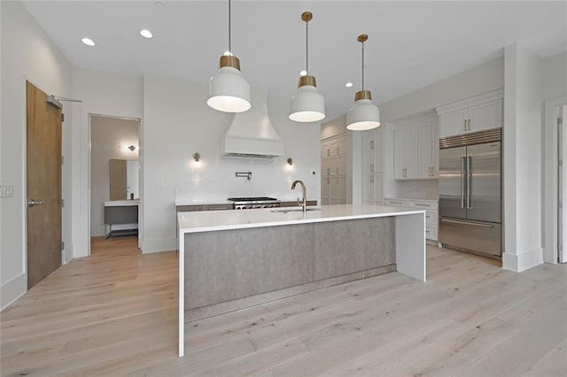 8200 Main St Unit 1206, Woodstock, GA 30188 - kitchen with built in fridge, premium range hood, a sink, light wood-style flooring, and recessed lighting