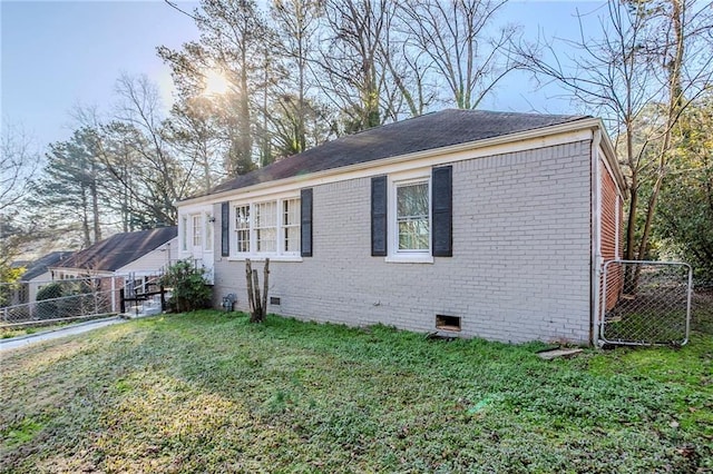 view of front facade with a front yard, crawl space, brick siding, and fence