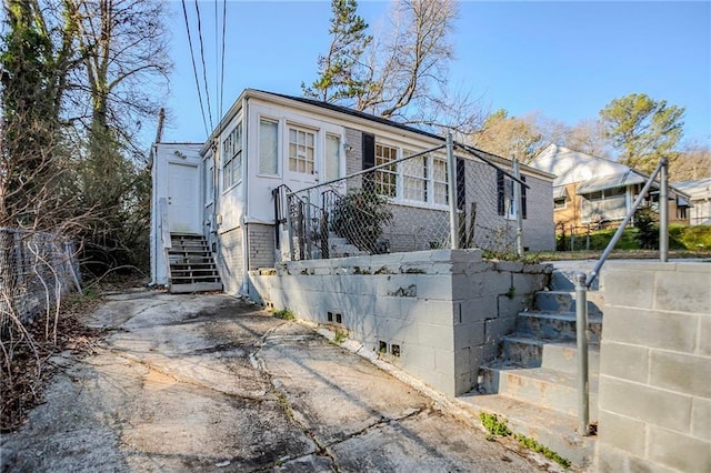 view of side of property with entry steps and brick siding