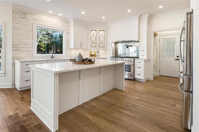 2470 Hopewell Plantation Dr, Milton, GA 30004 - kitchen with stainless steel appliances, wood finished floors, white cabinetry, a kitchen island, and light countertops