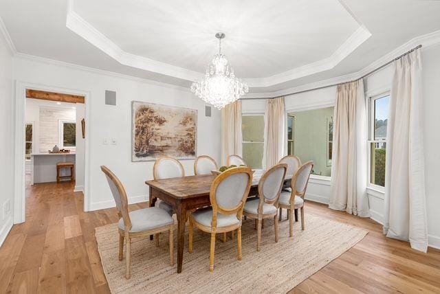 2470 Hopewell Plantation Dr, Milton, GA 30004 - dining room with a tray ceiling, crown molding, a chandelier, and light wood-type flooring