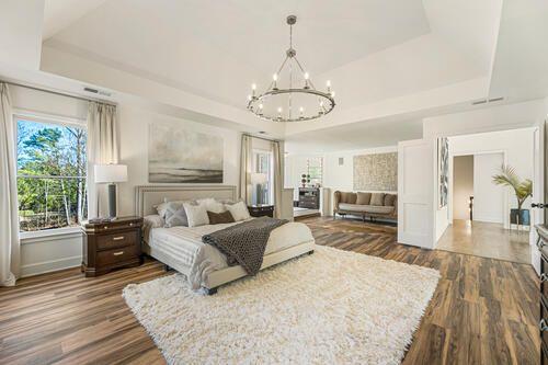 2470 Hopewell Plantation Dr, Alpharetta, GA 30004 - bedroom with a chandelier, a tray ceiling, and dark wood-type flooring
