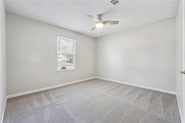 carpeted spare room with ceiling fan and a textured ceiling