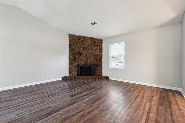 unfurnished living room with vaulted ceiling, a fireplace, and dark hardwood / wood-style floors