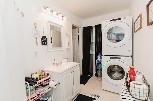 laundry area with sink, stacked washer / dryer, and light tile patterned flooring