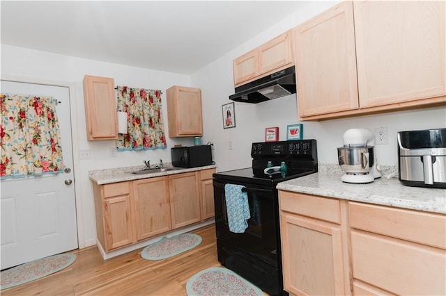 kitchen with black appliances, light brown cabinets, light hardwood / wood-style floors, sink, and light stone counters